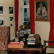 Gedenkzimmer Otto Flakes: Aufnahme des Raumes zur Fensterseite: links Ohrensessel, mittig der Schreibtisch, rechts ein Stuhl. Zwischen den Fenstern an der Wand ein Gemälde: Porträt Otto Flakes