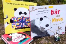 Drei Kinderbücher zum Thema Pandabär in der Natur fotografiert, davor ein kleiner Spielzeugpandabär.