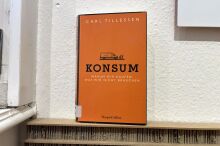 Buch über "Konsum" vor einer einfarbigen Tapete.
