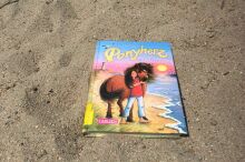 Das Buch "Ponyherz" liegt auf Sand.