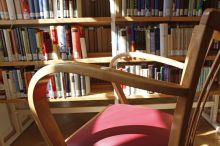 Ein Lehnstuhl, im Hintergrund ein Bücherregal