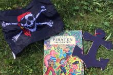 Zusammenstellung von Piratenfahne, Piratenbuch und Pappanker.