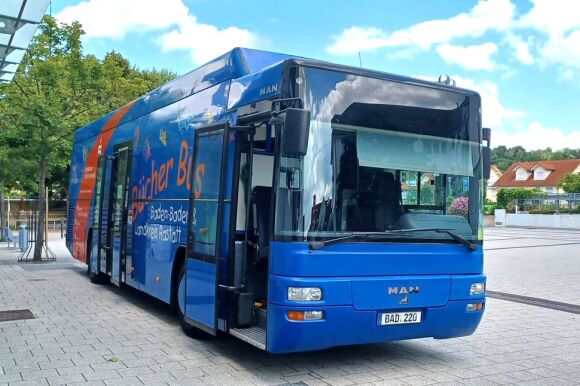Bücherbus auf menschen- und autolosem Platz unter blauem Himmel.