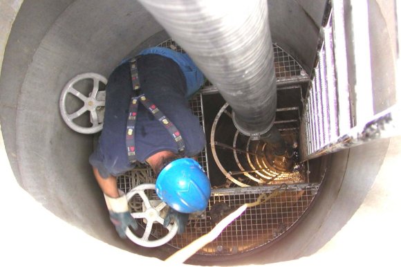 Offener Kanal ind dem an Mann mit blauem Helm arbeitet