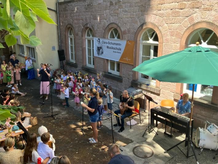Kinder und Lehrer stehen im Hof der Musikschule.