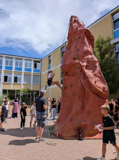 In einem Schulhof steht eine rote Kletterwand.
