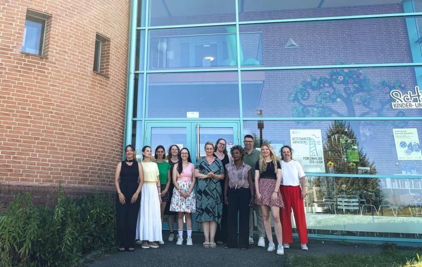 Gruppenbild vor dem Eingang des Scherer Kinder- und Familienzentrums: 10 Erzieherinnen und Bürgermeister Dr. Krammerbauer