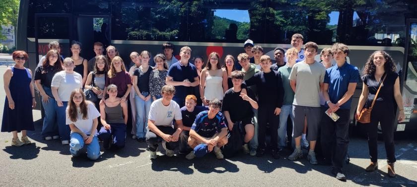 Schülerinnen und Schüler stehen vor einem Bus. 