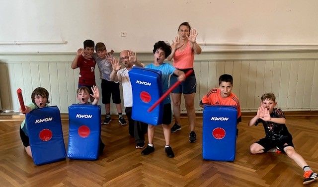 Gruppenbild mit Kindern und Trainern in einer Turnhalle.